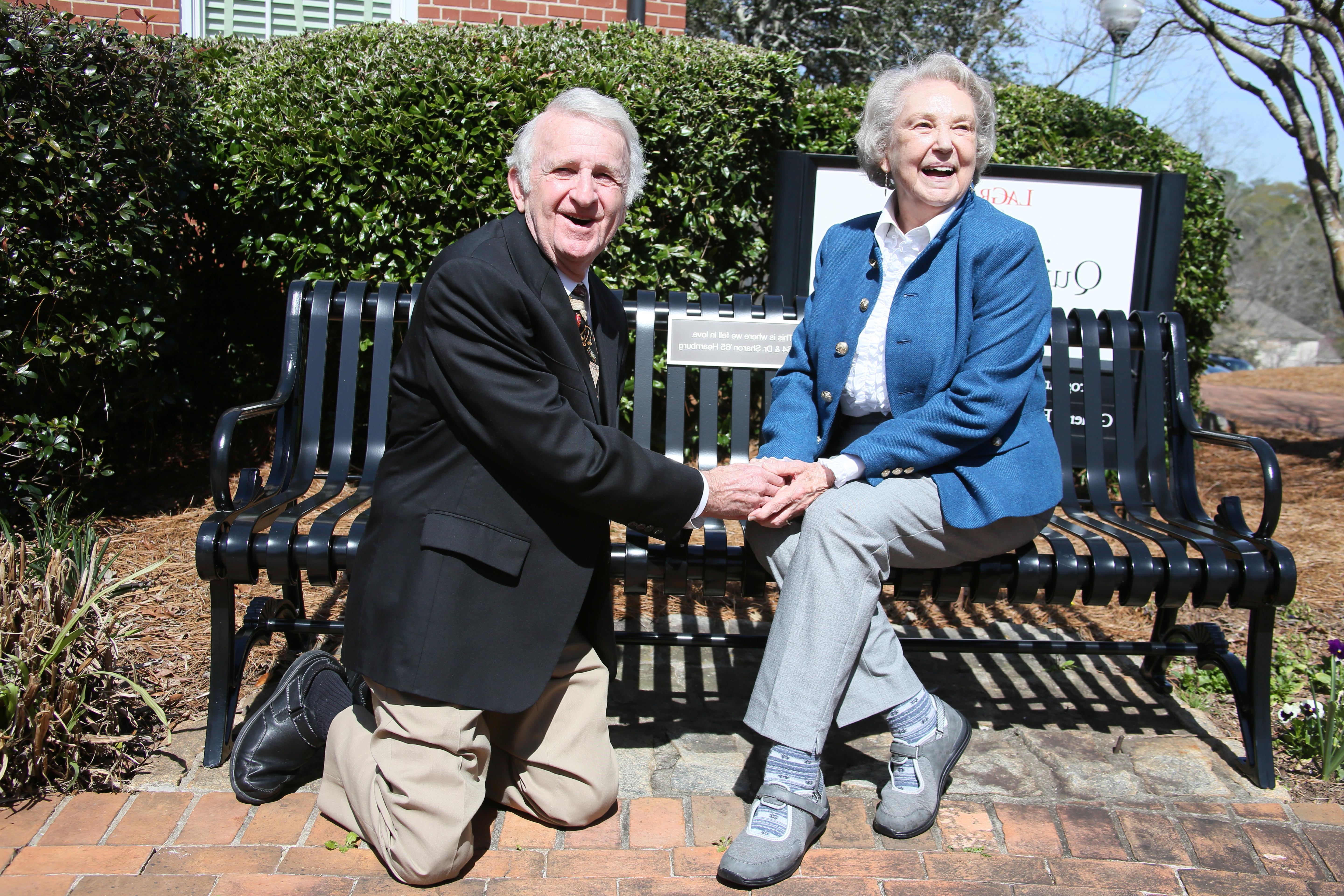 1964年的比尔和65年的沙伦·赫恩伯格在奎莉安大楼外的长凳前重现了他们的订婚场景. 